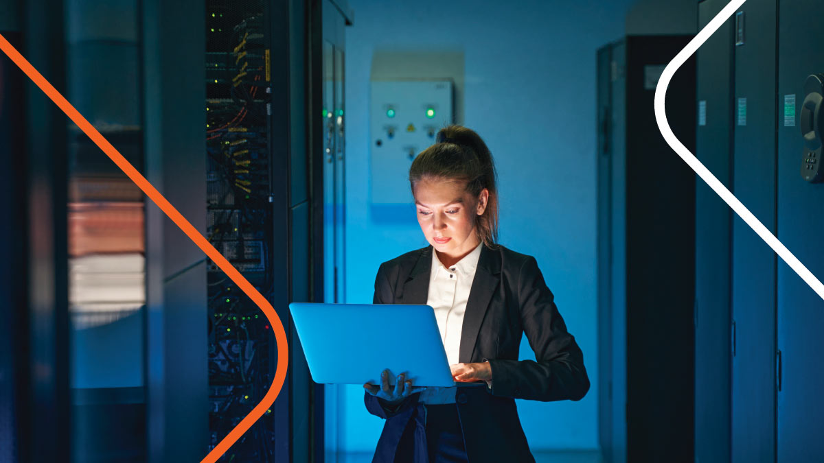 Technician working on laptop in server room